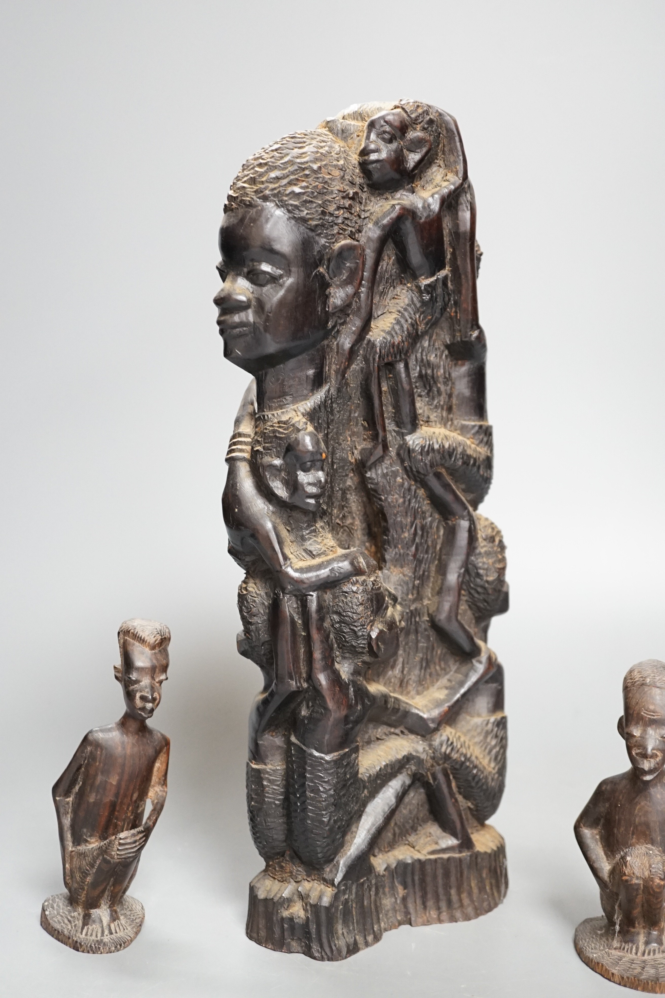 Four tribal hardwood carvings, two bows and two bronze spears longest 85cm